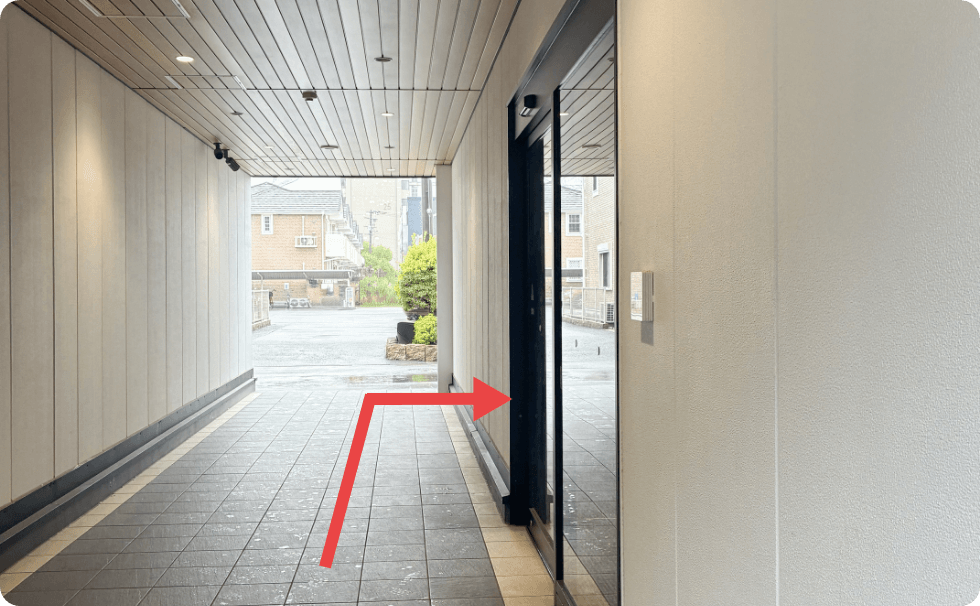 建物内通路から入口の自動ドアへ進む道順（矢印付き）